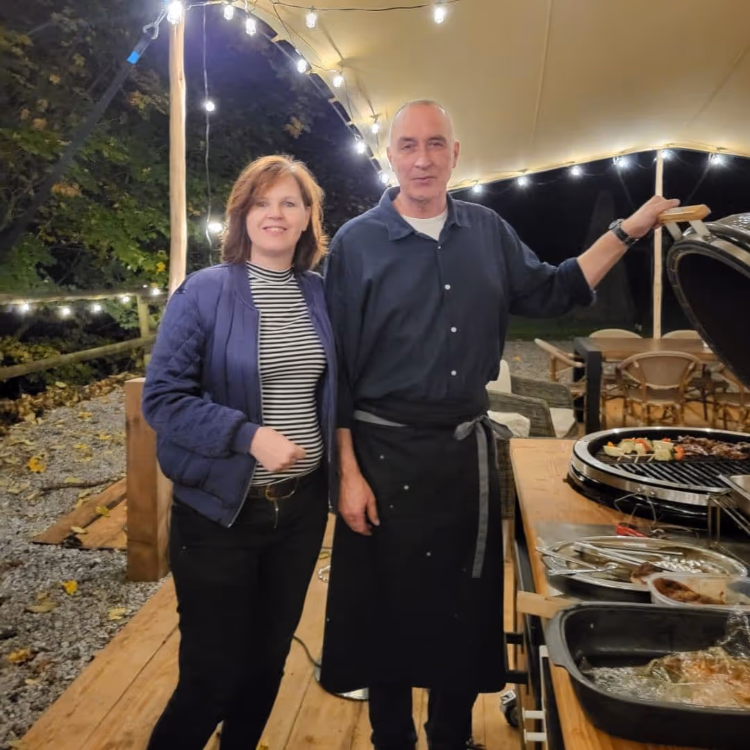 Emile und Rita, die niederländischen Gastgeber des Iris Valley Lodge, am Abend beim Outdoor Cooking unter der überdachten Terrasse in Herzberg am Harz
